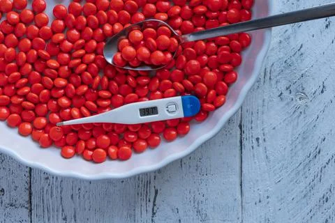 An electronic thermometer with a temperature mark of 39.7 in a large plate of Stock Photos