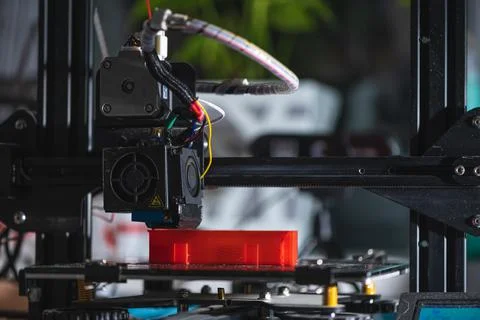 Electronic three dimensional plastic printer during work , prints red model Stock Photos