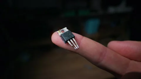 Electronic Transistor Component Held on Finger Tip for Hardware Engineering Stock Footage 339363985
