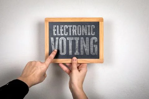 Electronic Voting Concept with Hands Pointing to Chalkboard Message Stock Photos