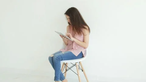 Electronics and personal gadgets concept. Young woman reading information on her Stock-Footage 92959955