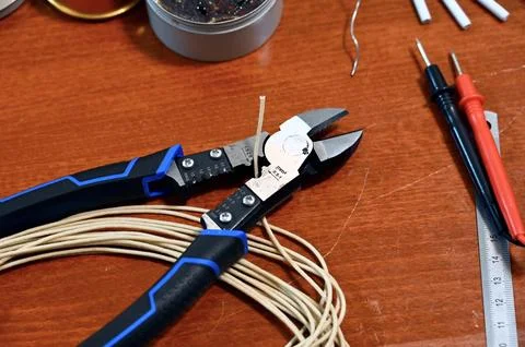 Electronics and soldering tool flat lay including multimeter, wire cutters, and Stock Photos