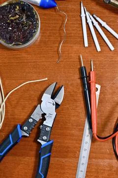 Electronics and soldering tool flat lay including multimeter, wire cutters, and Stock Photos