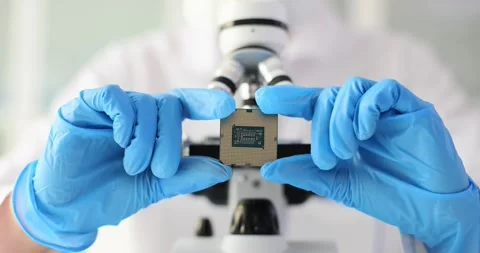 Electronics engineer in glove holds microcircuit against background of Stock Footage 254762988