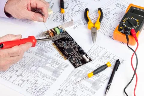 Electronics engineer soldering a component onto a computer card Stock Photos
