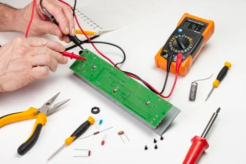 Electronics engineer testing a circuit board with a multimeter Stock Photos