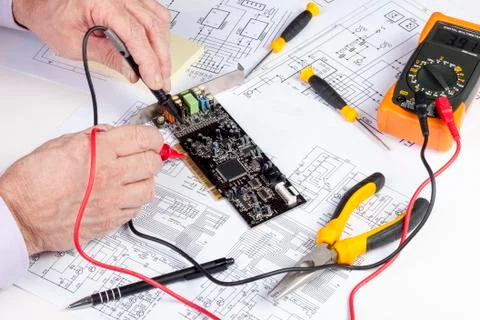 Electronics engineer testing a computer PCI card with a multi meter Foto stock