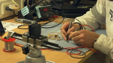 Electronics engineer testing head mic in his workshop and melting solder wire Stock Footage 105190894