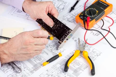 Electronics engineer using a screwdriver to secure a fixing plate Foto stock