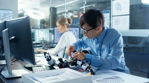 Electronics Engineer Works with Robot Checking Voltage and Program Response time Stock Footage 85768463