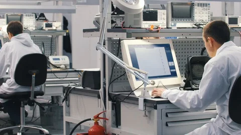 Electronics engineers working in lab. Engineers sitting at the table and working 動画素材 99446567