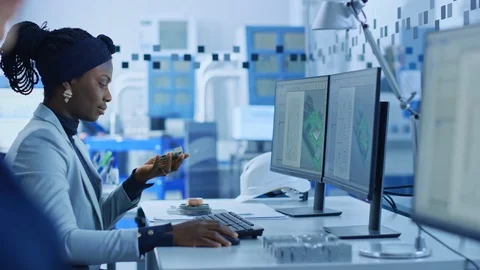 Electronics Factory: Female Electrical Engineer Holds PCB Prototype, Works on PC Stock Footage 123635052