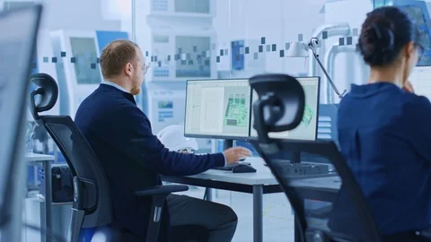Electronics Factory: Male Electrical Engineer Holds PCB Prototype, Works on PC Stock Footage 123635040