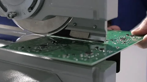 Electronics laboratory, Green plate of electronic parts being cut on a table saw Stock Footage 153982824