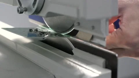 Electronics laboratory, Green plate of electronic parts being cut on a table saw Stock Footage 153985909