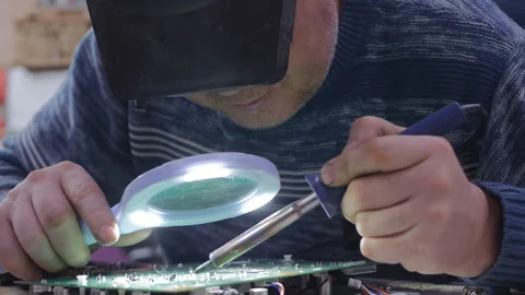 Electronics repair locksmith Caucasian man makes soldering of a microcircuit Video stock 143625163