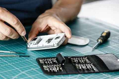 Electronics repair service. Technician disassembling smartphone for inspecting Stock Photos