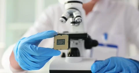Electronics scientist working with a microscope and looking at microchip Video stock 258881391