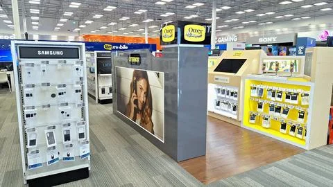 Electronics store interior with displays and merchandise shelves. Stock Photos