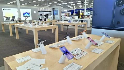 Electronics store interior showcasing smartphones on display tables. Stock Photos