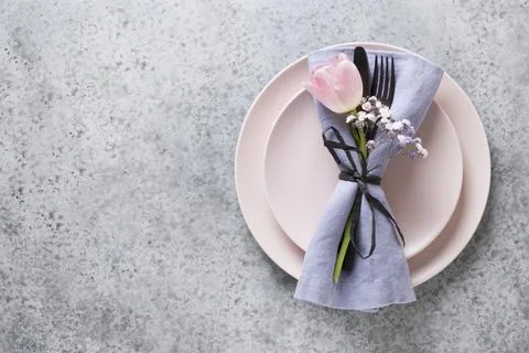 Elegance spring table setting with pink tulip on grey. Easter dinner. Top vie Stock Photos