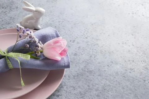 Elegance spring table setting with pink tulip on grey. Easter dinner. Stock Photos