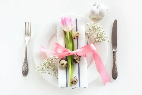 Elegance table setting with pink ribbon and tulip. Easter romantic dinner. Stock Photos