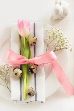 Elegance table setting with pink ribbon and tulip. Easter romantic dinner. Stock Photos
