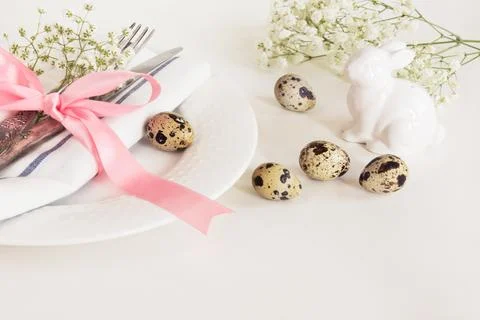 Elegance table setting with pink ribbon and flower. Easter romantic dinner. Stock Photos
