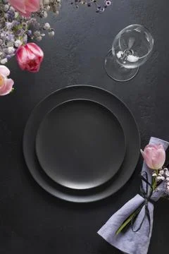 Elegance table setting spring pink tulip on black. Easter dinner. Top view. Stock Photos