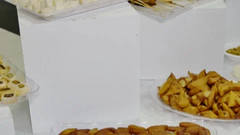 Elegant appetizer buffet featuring chicken satay skewers, assorted wraps, crispy Stock Footage 334764270