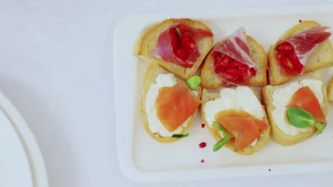 Elegant appetizers combining crispy toasted bread, creamy cheese, smoked salmon Stock Footage 332570786