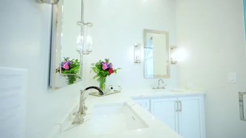 Elegant bathroom interior featuring a white vanity, chrome fixtures, wall Stock Footage 323453586