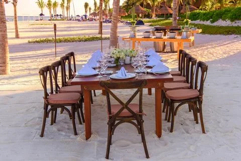 Elegant Beach Dinner Setup at Sunset Stock Photos