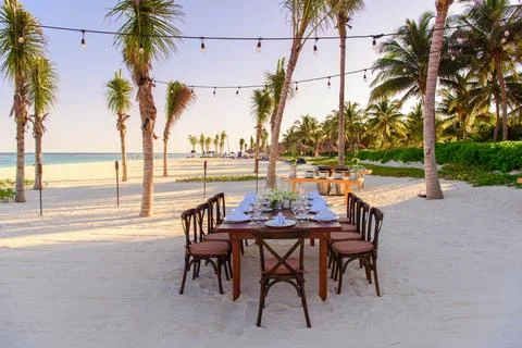 Elegant Beach Dinner Setup at Sunset Stock Photos