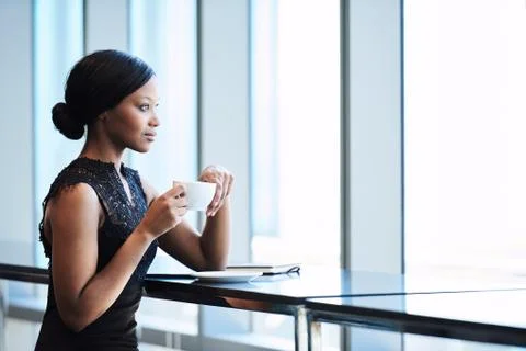 Elegant black female looking out window with her morning tea Stock Photos