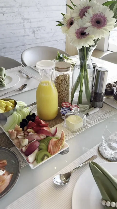 Elegant breakfast setting with fresh fruit, juice, and sophisticated table Video stock 318553290