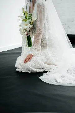 Elegant bride standing back to camera in a lace wedding dress with a long train. Fotos Stock