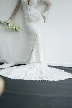 Elegant bride standing back to camera in a lace wedding dress with a long train. Foto stock