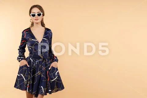 Elegant brunette woman in dress and heels and sunglasses. Stock Photos