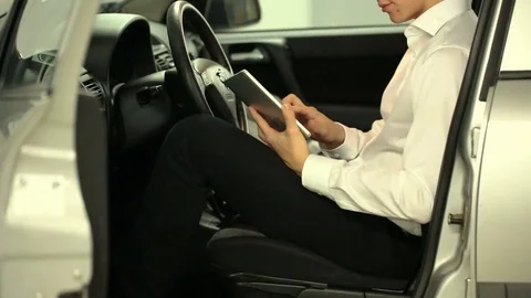 Elegant businessman browsing internet on tablet while sitting in the car Stock Footage 80397074