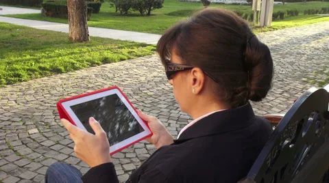 Elegant businesswoman using a tablet computer on a bench Stock Footage 32502703
