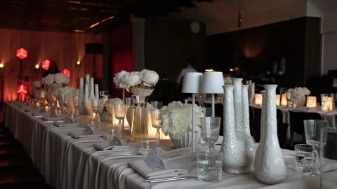 Elegant Candlelit Banquet Table Setting With White Flowers and Ambient Lighting Stock Footage 339044690