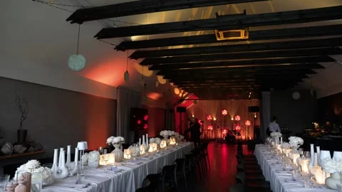 Elegant Candlelit Dinner Setup in Modern Banquet Hall with Warm Ambient Lighting Stock Footage 339044845