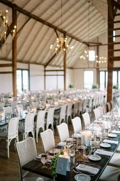 Elegant candlelit wedding reception in rustic barn Stock Photos