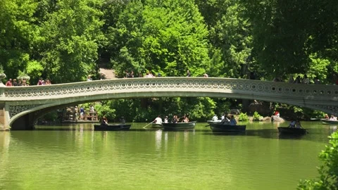 The elegant cast-iron Bow Bridge spans the waterway as one of Central Park’s Vídeos de archivo 338315434