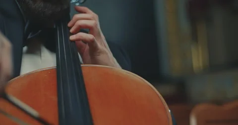 An elegant cellist is performing beautifully while dressed in formal attire at a 動画素材 303432867