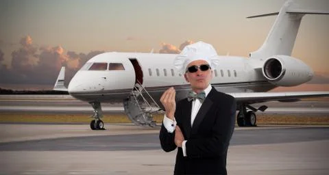 Elegant chef gesturing in front of private jet Stock Photos