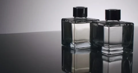 Elegant Clear Perfume Bottles on Reflective Surface with Minimalistic Background Stock-Footage 313052604