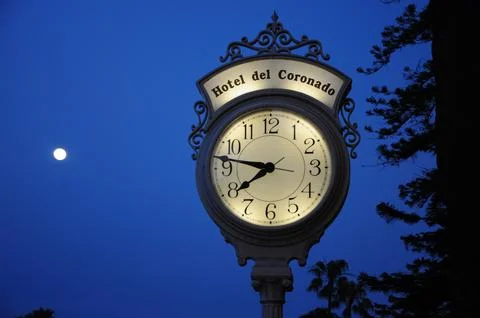 Elegant clock with deep blue evening sky at historic coastal hotel Stock Photos